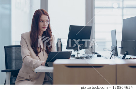 A Professional Woman excels in a Modern Office, demonstrating her expertise and dedication A Professional Woman excels in a Modern Office, demonstrating her expertise and dedication 128864634