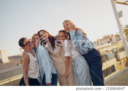 A Joyful Group of Friends Smiling Together, Making Memories Outdoors at Beautiful Sunset A Joyful Group of Friends Smiling Together, Making Memories Outdoors at Beautiful Sunset 128864647