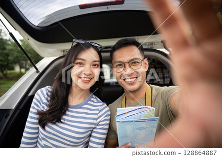 Couple capturing joyful moment during road trip selfie Couple capturing joyful moment during road trip selfie 128864887