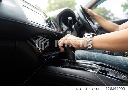 Driver shifting gears in modern car, ready for adventure Driver shifting gears in modern car, ready for adventure 128864903