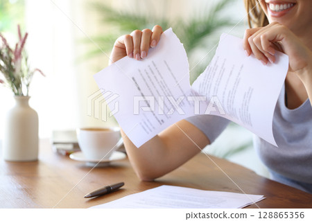 Happy woman breaking document or contract at home 128865356