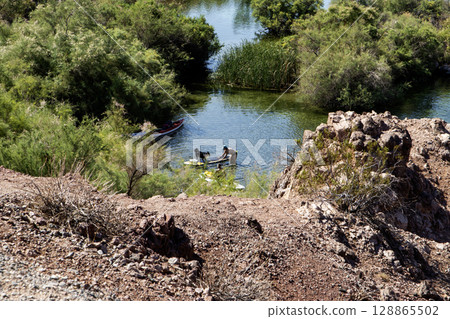 Women and her dog getting on a paddleboard to float down a river 128865502