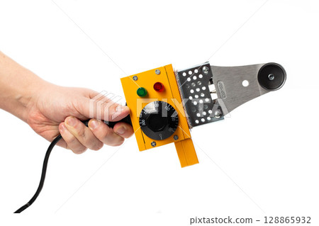 Electric soldering iron for soldering pipes in hand on a white background, isolate, close-up 128865932