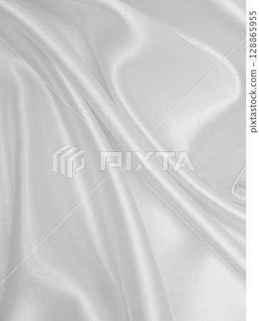 Smooth elegant white silk or satin luxury cloth texture as wedding background. Luxurious background design Smooth elegant white silk or satin luxury cloth texture as wedding background. Luxurious background design 128865955