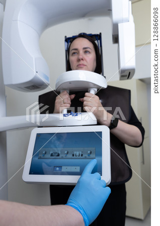 Patient Undergoing Dental Imaging Procedure with Advanced 3D Technology for Accurate Diagnosis and Treatment Planning in Modern Dental Office 128866098