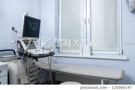 Modern Ultrasound Examination Room Showing Diagnostic Equipment and Clean Environment for Medical Imaging Procedures Modern Ultrasound Examination Room Showing Diagnostic Equipment and Clean Environment for Medical Imaging Procedures 128866147