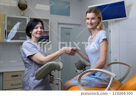 A Dentist and Patient Shake Hands in a Modern Dental Clinic, Highlighting a Trusting Relationship and a Positive Atmosphere in Dental Healthcare Services 128866300