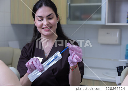 A Friendly Medical Professional Preparing Tools for a Procedure in a Modern Clinic Environment with a Bright Smile and Professional Attire 128866324