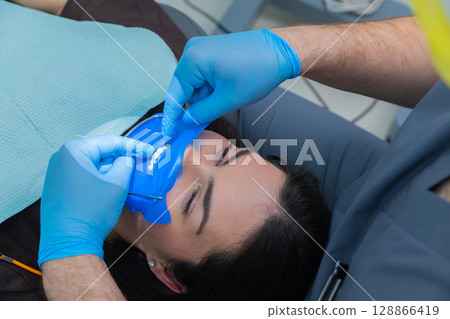 Dental Procedure: A Professional Guide to Ensuring Patient Comfort During Treatment with Protective Measures Using Rubber Dams and Protective Gear Dental Procedure: A Professional Guide to Ensuring Patient Comfort During Treatment with Protective Measures Using Rubber Dams and Protective Gear 128866419