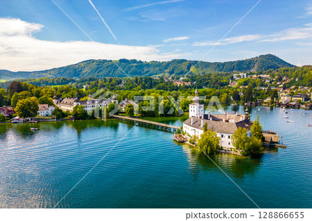 Schloss Ort (or Schloss Orth) is an Austrian castle situated in the Traunsee lake, in Gmunden. Aerial drone view. Schloss Ort (or Schloss Orth) is an Austrian castle situated in the Traunsee lake, in Gmunden. Aerial drone view. 128866655