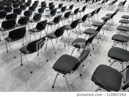Rows of empty chairs arranged in a spacious convention hall prior to an event in the morning 128867268