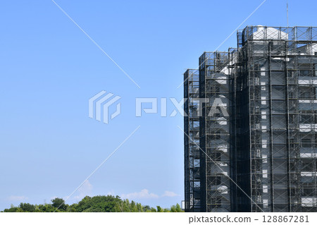 日本橫濱城市景觀：夏日天空蔓延......公寓大樓維修和檢查的鷹架和防護網的景色=24日 128867281