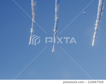 Three icicles hanging from the sky 128867509