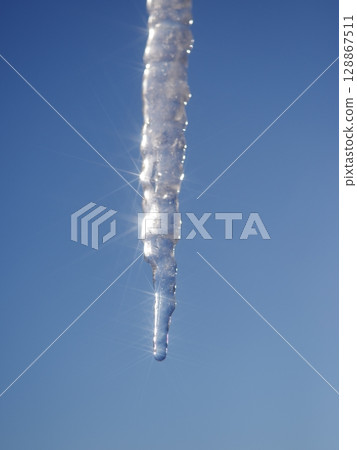 A long icicle hanging from the sky 128867511