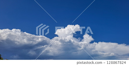 Beautiful cumulus clouds. Against the blue sky there is a distinctive cloud front. Beautiful cumulus clouds. Against the blue sky there is a distinctive cloud front. 128867824