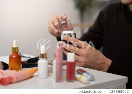 Skincare Application. Young man opening cream jar for personal care. Skincare Application. Young man opening cream jar for personal care. 128868632