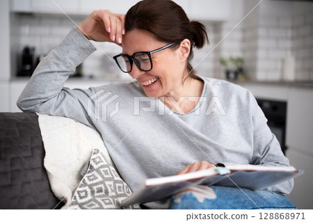Happy Young Woman Reading A Book And Laughing Happy Young Woman Reading A Book And Laughing 128868971