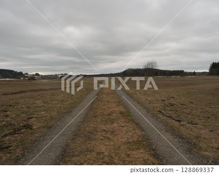 Road is shown in the distance with a cloudy sky above 128869337