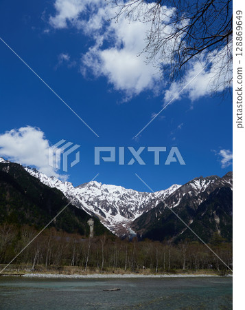 Beautiful spring blue sky and snowy mountain scenery of the Hotaka mountain range in Kamikochi, a popular tourist spot Beautiful spring blue sky and snowy mountain scenery of the Hotaka mountain range in Kamikochi, a popular tourist spot 128869649