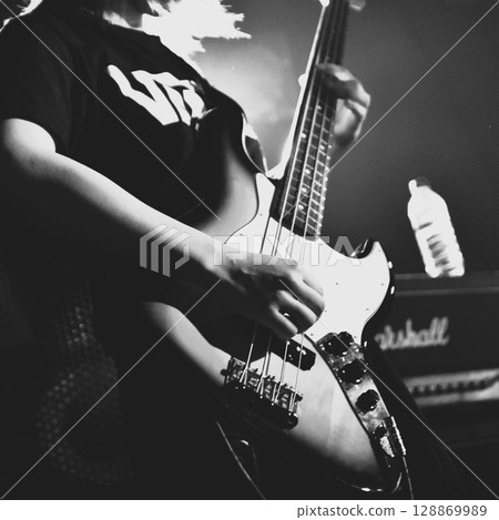 Monochrome female bassist performing 128869989