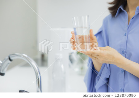 一個女人在廚房喝水 128870090