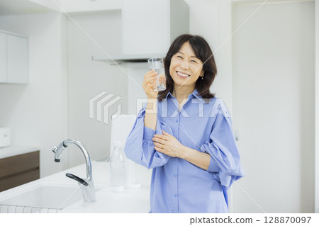 一個女人在廚房喝水 128870097