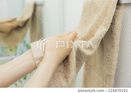 Woman wiping hands with towel 128870181