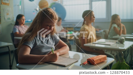 Team of Smart Diverse Kids Sitting at Desks, Studying Ecology, Listening to Lecture from Teacher 128870433