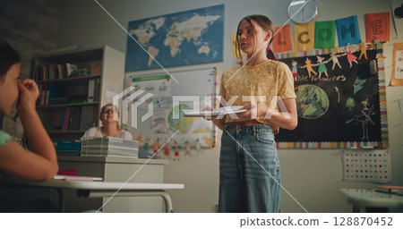Primary School Girl Holding Notebook Speaking, Showcasing Knowledge of Ecology 128870452