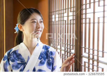 A woman in a yukata in a Japanese-style room A woman in a yukata in a Japanese-style room 128870595