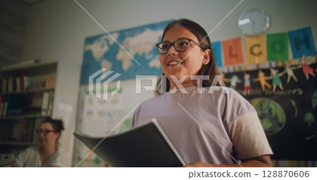 Renewable Energy Lesson: Elementary School Girl Speaking, Giving Presentation in Front of Classmates Renewable Energy Lesson: Elementary School Girl Speaking, Giving Presentation in Front of Classmates 128870606