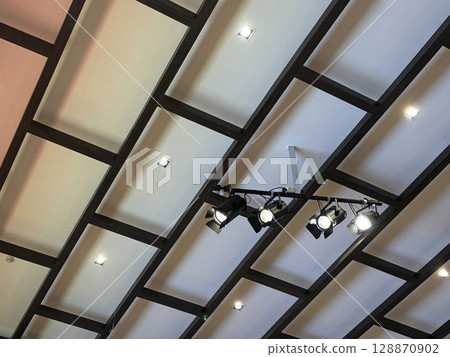 Ceiling with lighting and a ceiling spotlight bar, and modern black frames. 128870902