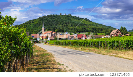 Alsace region of France - famous "wine route" road popular tourist destinations. beautiful vineyards and traditional village Husseren les chateaux Alsace region of France - famous "wine route" road popular tourist destinations. beautiful vineyards and traditional village Husseren les chateaux 128871405