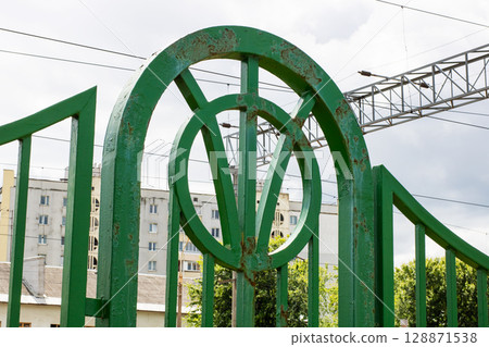 There is a green fence that has the letter v prominently displayed on it 128871538