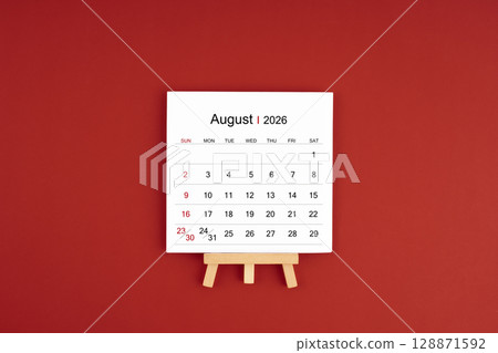 Calendar page for August 2026 with wood easel on a dark red background. 128871592