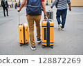 Tourists walking with luggage toward city 128872269