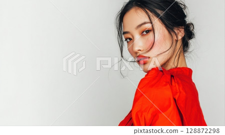 Fashion portraits of Asian women in bright red outfits posing against white backgrounds 128872298