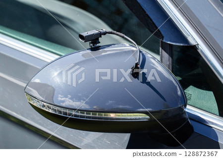Black car outside air temperature gauge on car rearview mirror background, measuring cold and hot air temperature, close-up Black car outside air temperature gauge on car rearview mirror background, measuring cold and hot air temperature, close-up 128872367