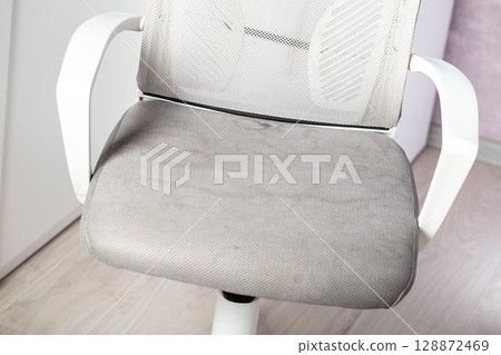 Dirty gray upholstery fabric with stains on computer chair before dry cleaning, close-up 128872469