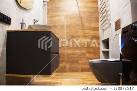 Contemporary bathroom with wood effect tiles, grey wall hung cabinet and toilet. Copy space for text. Stylish interior Contemporary bathroom with wood effect tiles, grey wall hung cabinet and toilet. Copy space for text. Stylish interior 128872517