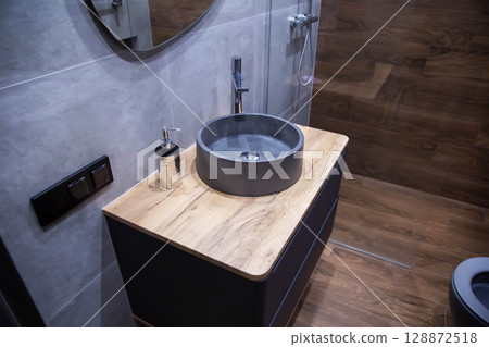 Modern grey stone sink in wall hung vanity in bathroom. New stylish bathroom renovation. Copy space for text. Reinforced water tap Modern grey stone sink in wall hung vanity in bathroom. New stylish bathroom renovation. Copy space for text. Reinforced water tap 128872518