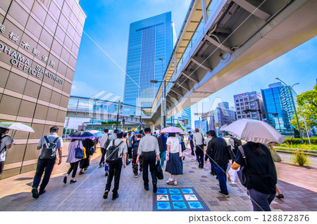 Yokohama cityscape in Japan: Morning commute to work. In the background is Yokohama City Hall in front of Sakuragicho Station. Yokohama cityscape in Japan: Morning commute to work. In the background is Yokohama City Hall in front of Sakuragicho Station. 128872876