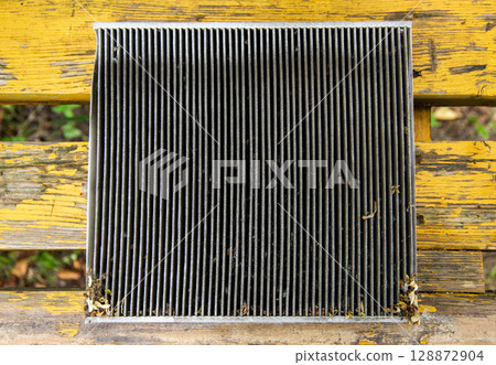 Replacing an old dirty cabin filter with a new one. Car maintenance, close-up Replacing an old dirty cabin filter with a new one. Car maintenance, close-up 128872904