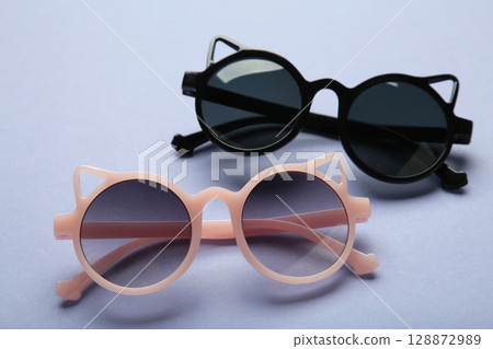 Kids sunglasses on purple background. Sun protection Kids sunglasses on purple background. Sun protection 128872989