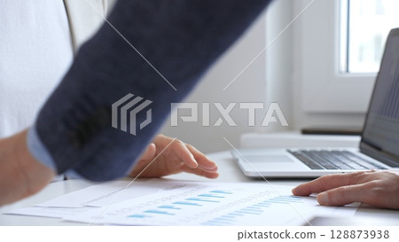 Professional team analyzing financial data, discussing graphs and strategic insights during collaborative workplace meeting. Business people concept 128873938