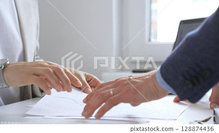 Professional team analyzing financial data, discussing graphs and strategic insights during collaborative workplace meeting. Business people concept 128874436