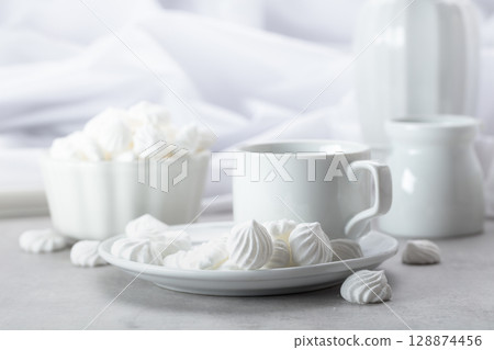 Vanilla meringue and coffee cup on a white marble table. Vanilla meringue and coffee cup on a white marble table. 128874456