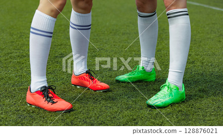 Women soccer athletes donned vibrant cleats on lush green field Women soccer athletes donned vibrant cleats on lush green field 128876021
