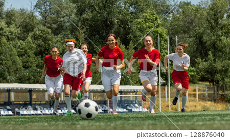 Female soccer athletes competing on outdoor field 128876040