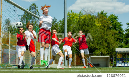Female soccer players in goalmouth action during intense match 128876051